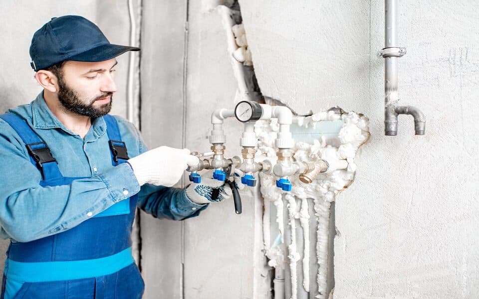 Workman installing water heating system